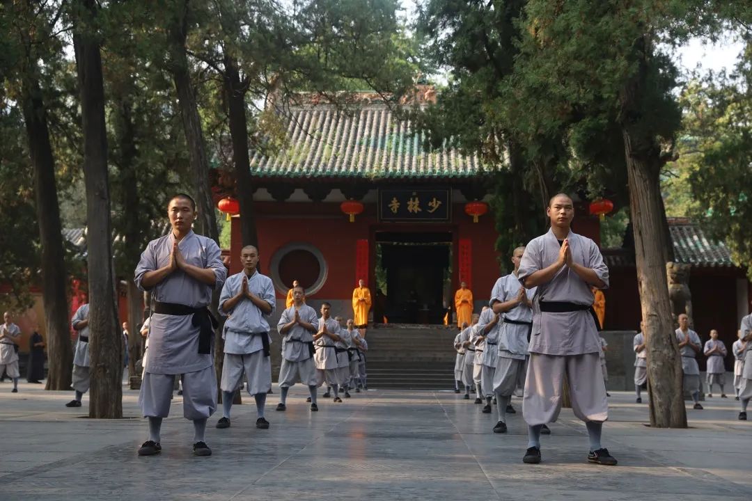Shaolin monks practicing meditation outside a traditional Buddhist temple