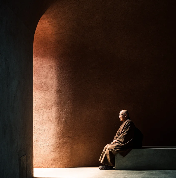 Monk meditating in serene temple light, embodying Buddhist mindfulness and peace