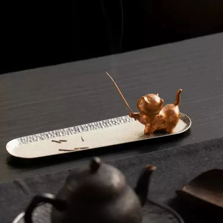 Cute cat incense holder with smoking stick on textured tray, ideal for mindfulness decor