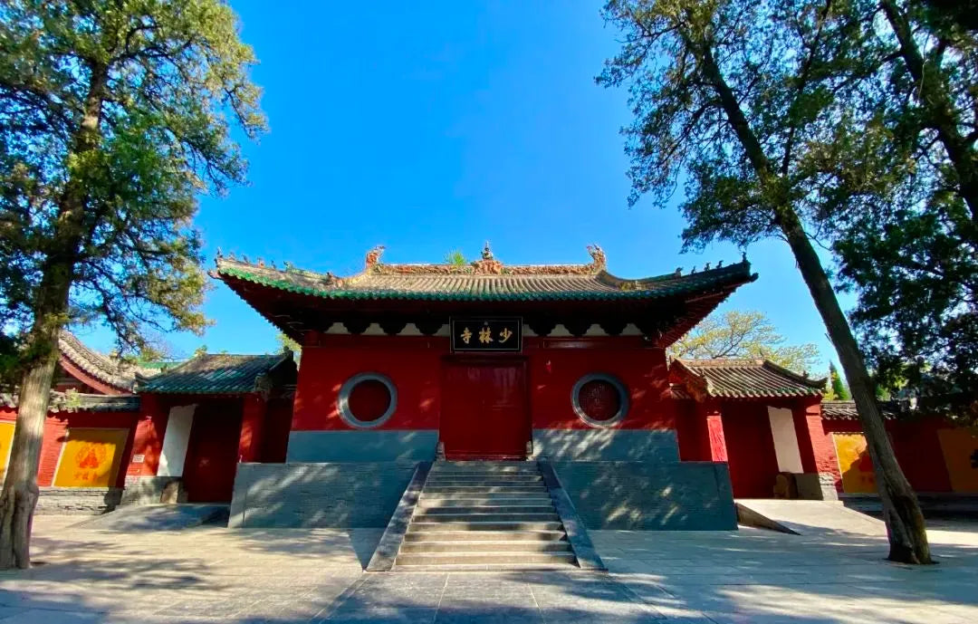Historic Shaolin Temple entrance with red walls, circular windows, and traditional Chinese roof.