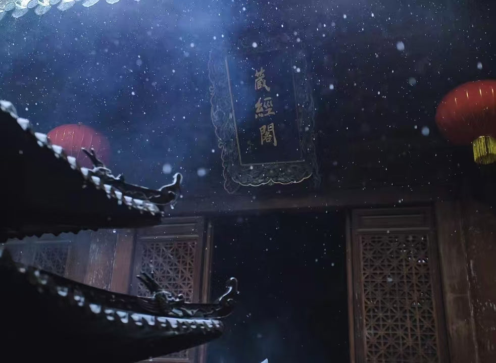 Incense smoke and lanterns at the entrance of a traditional Buddhist temple in snowfall.