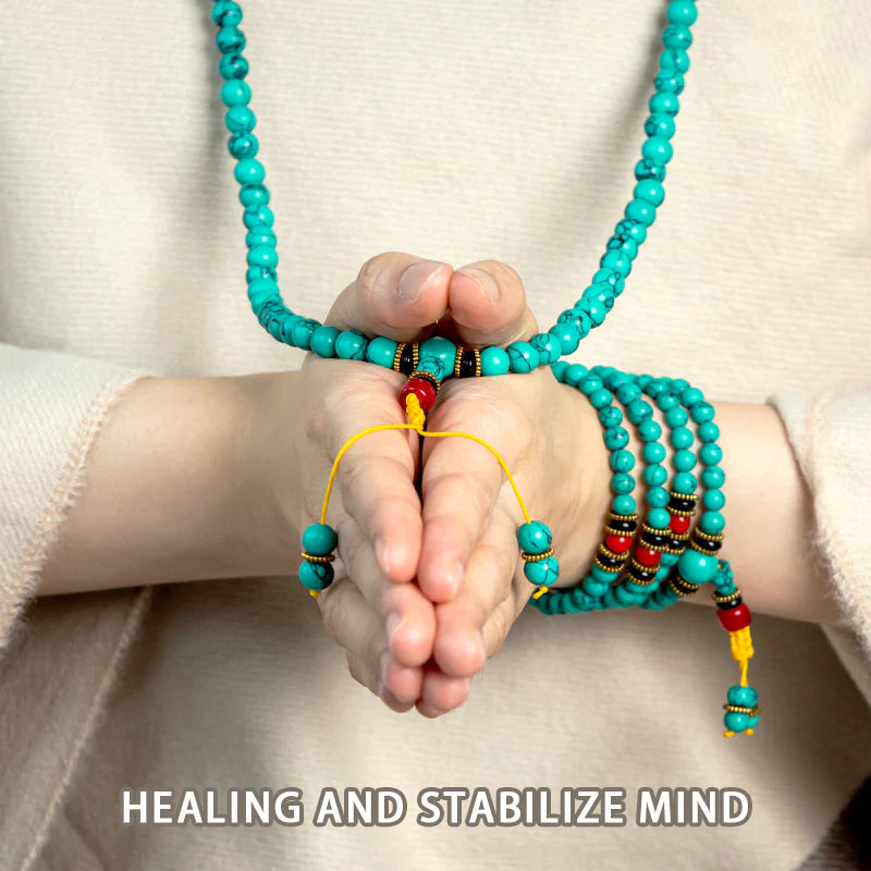 Turquoise prayer beads with red accents, held in hands for meditation and mindfulness practice