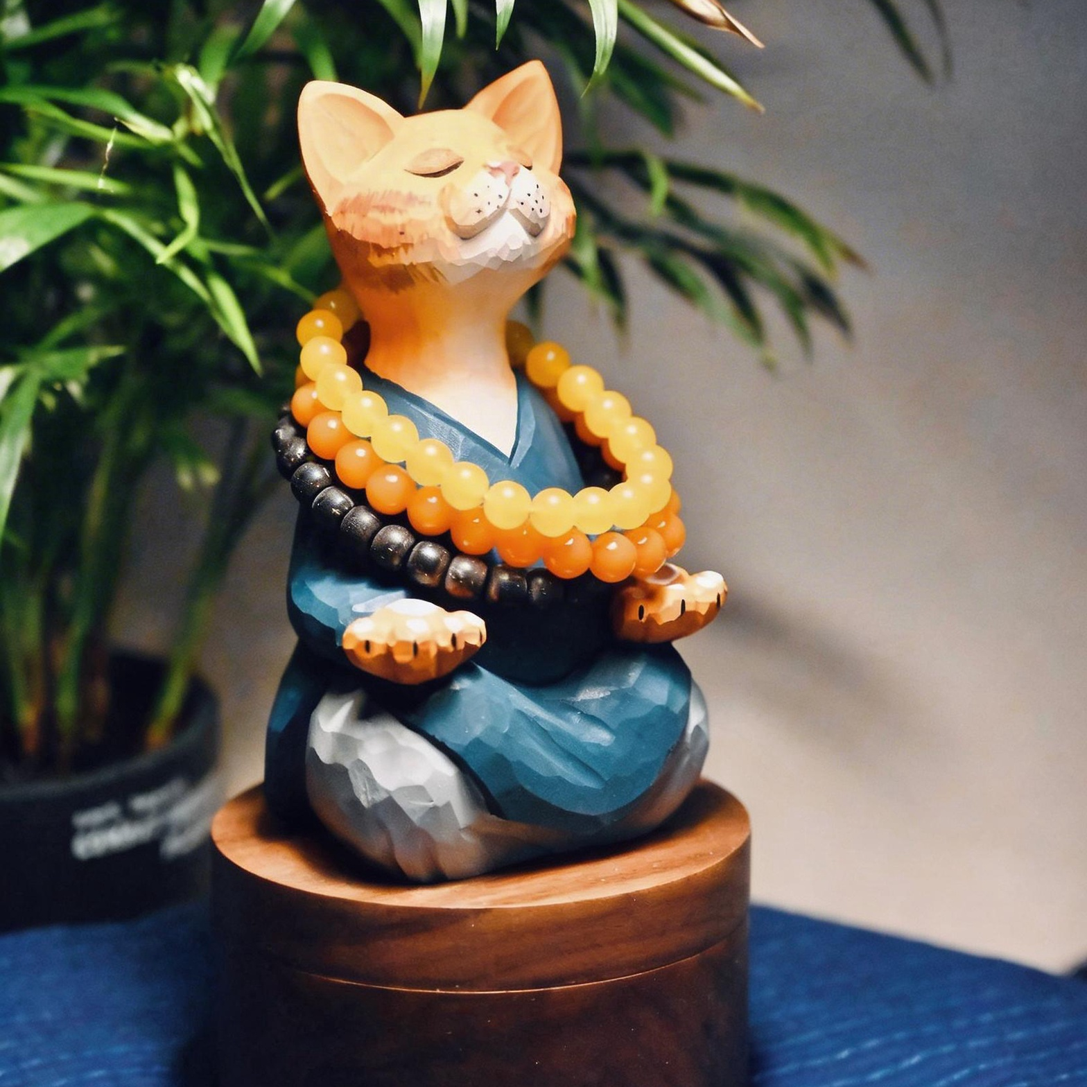 精神統一する猫：安らかな青いローブをまとった職人手彫りの木製置物