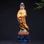 Guanyin Buddha statue in golden robe holding prayer beads, standing on lotus base with blue waves, for altar decor and mindfulness.