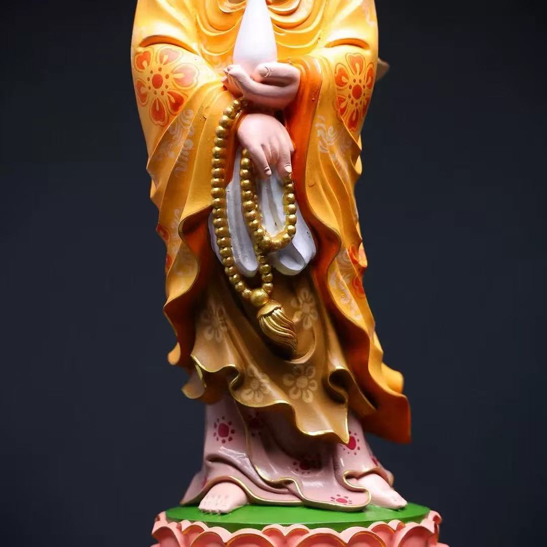 Buddha statue in golden robe holding prayer beads, standing on lotus base for altar decor