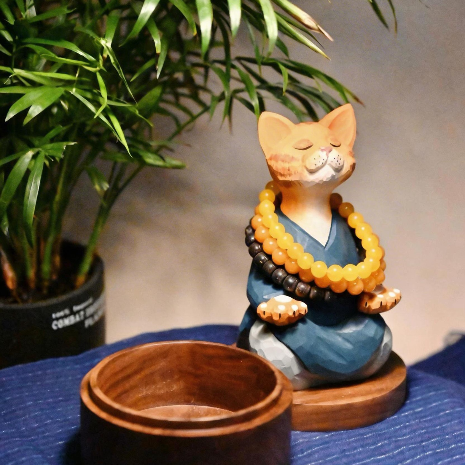 精神統一する猫：安らかな青いローブをまとった職人手彫りの木製置物