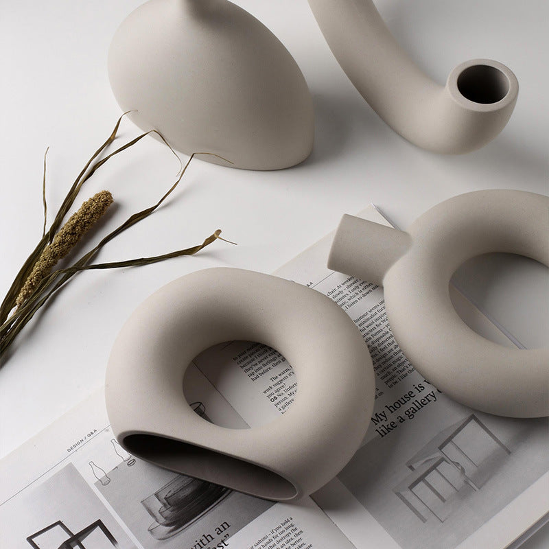 Minimalist ceramic incense holders with abstract shapes, styled with dried grass on magazine for mindful decor