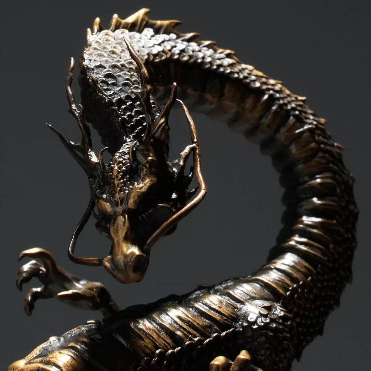Close-up of a bronze dragon statue with detailed scales and fierce expression, Buddhist decor